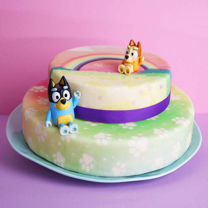 Bluey®-Figur auf 2-stöckiger Regenbogen-Torte