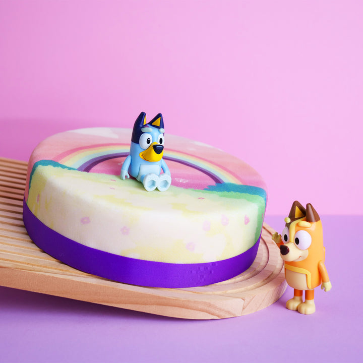Bluey®-Figur auf Regenbogen-Torte