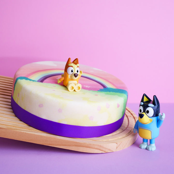 Bluey®-Figur auf Regenbogen-Torte