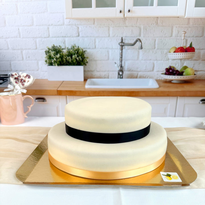 Zweistöckige weiße Torte mit Tortenband